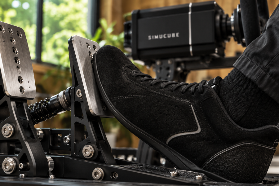 Driver applying a load cell brake on a rigid sim racing pedal platform.